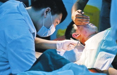 孩子身上有7道傷痕，其中兩道需要縫合，其他的均為擦傷，醫(yī)生正對(duì)他施治。
