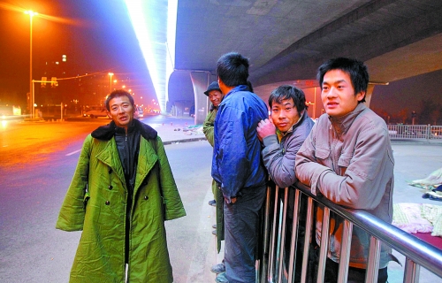 冬夜里，農(nóng)民工在橋下等著干活兒。