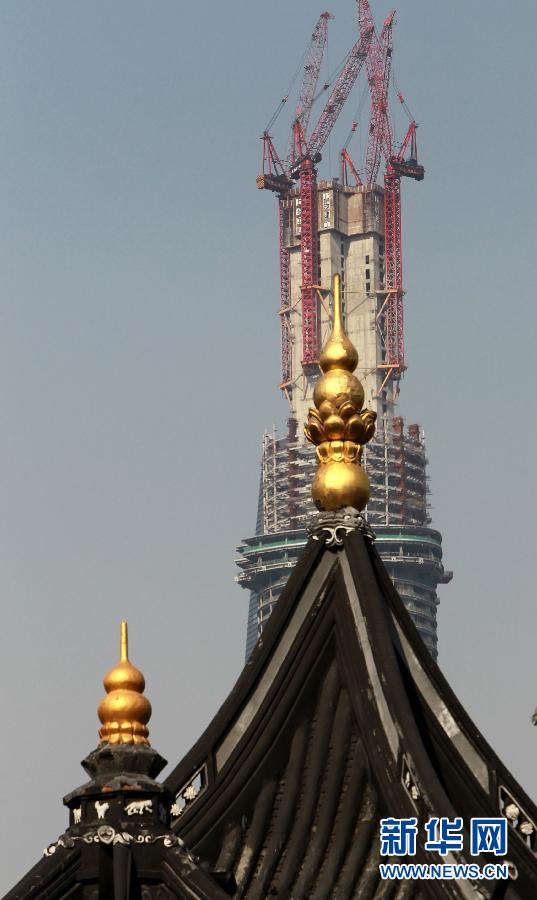 正在建設(shè)中的“上海中心”與豫園地區(qū)的傳統(tǒng)建筑（前）（4月11日攝）。