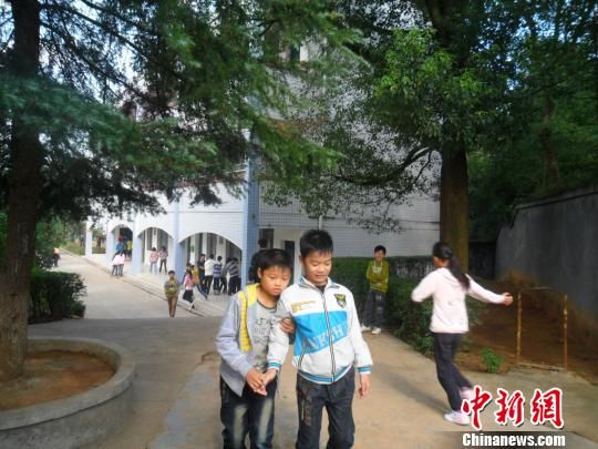 4年來，13歲的余興泉（左一）每天都攙扶著腿腳不便的同學(xué)左臣進出教室、食堂和廁所。 李俊杰 攝