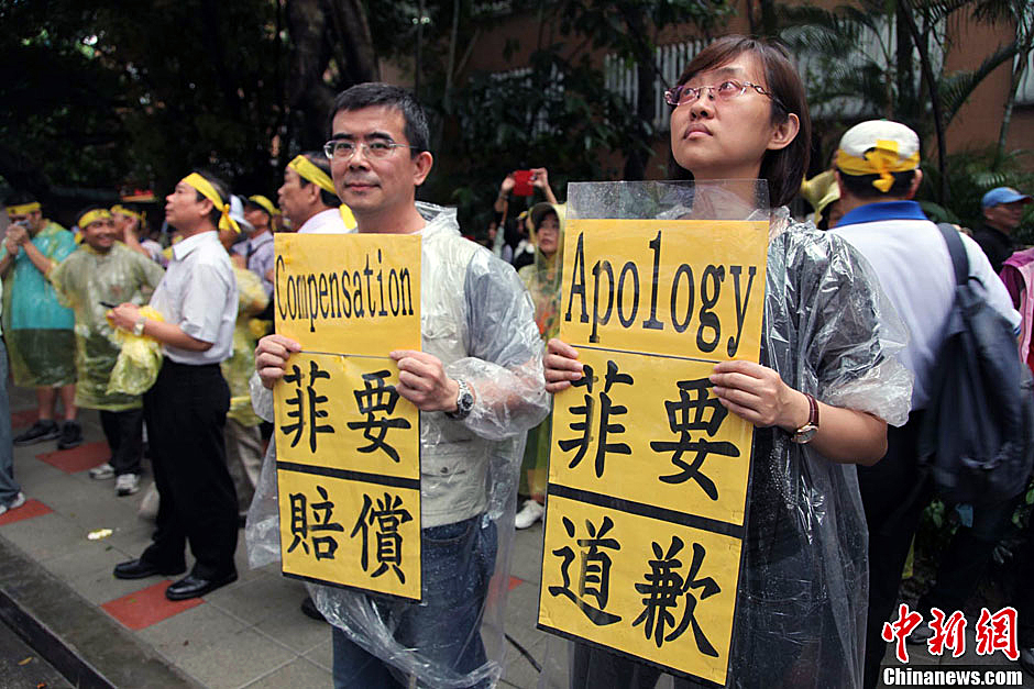 　圖為當(dāng)天下午，當(dāng)臺(tái)灣數(shù)百漁民在馬尼拉經(jīng)濟(jì)文化辦事處前抗議時(shí)，有兩名年輕人手持標(biāo)語，在路邊聲援。中新