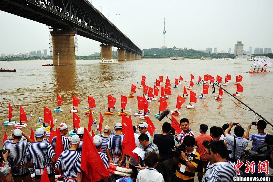 圖為江面上的橫渡方隊(duì)里的選手們劈波斬浪。中新社發(fā) 張暢 攝