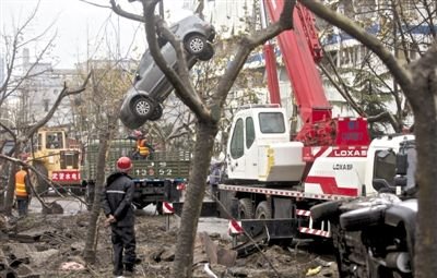 輸油管道爆炸后，搶修人員將被炸毀的車輛運(yùn)出現(xiàn)場(chǎng)。