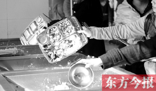 11月27日，河南中醫(yī)學(xué)院餐廳，一名同學(xué)將餐盤內(nèi)沒吃完的食物倒入餐具回收車內(nèi)