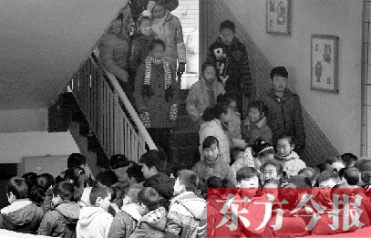 　某小學(xué)的學(xué)生走下樓梯放學(xué)。
