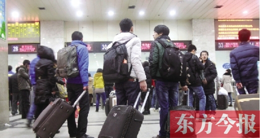 鄭州火車站東廣場售票大廳，幾名學生在售票窗口前躊躇