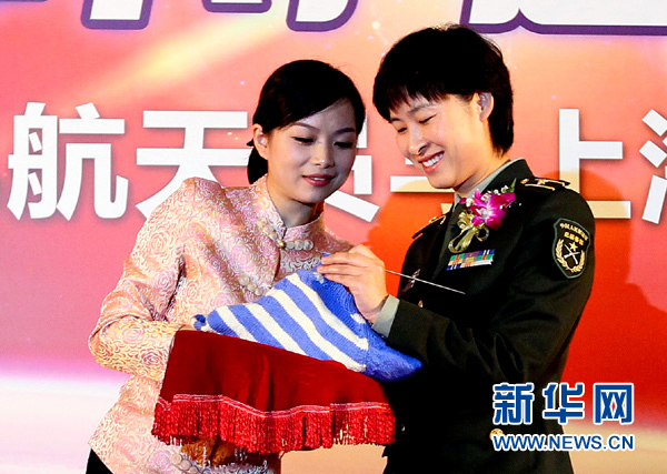 11月1日，航天員劉洋（右）在為“愛心”毛衣編織最后的收尾針。