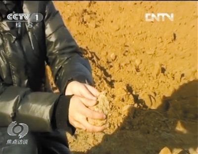 麻剛沙系麻剛石粉碎而成。記者找到一塊麻剛石，一捏就碎成粉末，硬度非常差。央視截圖