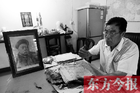 　魏樹紹手拿《物權(quán)法講義》手稿，在講訴先祖書寫“物權(quán)法”的歷史（相框里就是魏聯(lián)奎）