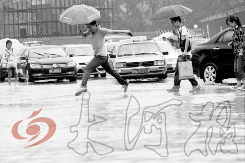 鄭州經(jīng)三路與北環(huán)交叉口處，積水較深，行人們不得不“練輕功”。 記者 白周峰 攝影