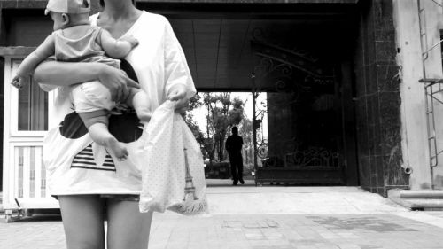 抱著孩子出售人奶的女子。