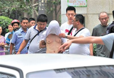 昨日，成都警方抓捕時(shí)與毒犯發(fā)生槍?xiě)?zhàn)。一名男犯罪嫌疑人被警方押出。
