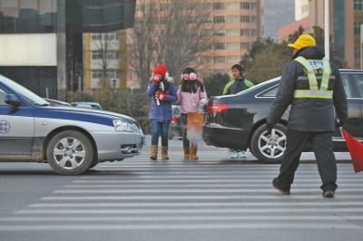 過斑馬線，行人左顧右盼，汽車寸土必爭(zhēng)。
