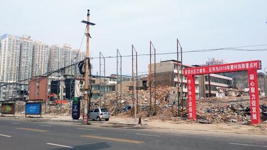 015年5月31日，在社區(qū)干部的帶頭拆遷下，親賢社區(qū)的“城中村改造”拉開帷幕。由于前期“清產(chǎn)核資”及補(bǔ)償標(biāo)準(zhǔn)等因素，拆遷改造工作推進(jìn)并不順利。圖為位于體育西路東側(cè)集體所有的商鋪率先被拆遷完畢，用于遮擋的圍擋正在施工中。（拍攝：2015年9月16日）