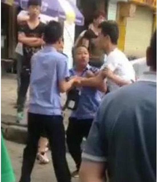 付某（右）與城管執(zhí)法人員廝打在一起。