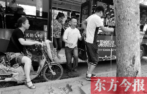 每到下車時(shí)，宋鵬（右一）和胡興開（右二）都很艱難，好在周圍的市民都挺照顧的