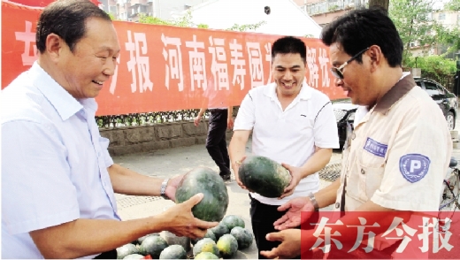 河南福壽園區(qū)域總經(jīng)理吳正宗（左一）、東方今報(bào)發(fā)行中心副總監(jiān)王路喜（中）在街頭給市民送瓜