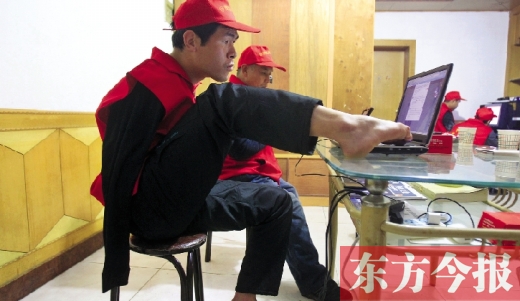 12月2日，一名“豫殘聯(lián)盟”志愿者正通過網(wǎng)絡(luò)、微博等聯(lián)絡(luò)著各地殘疾人朋友 東方今報首席記者 張曉冬