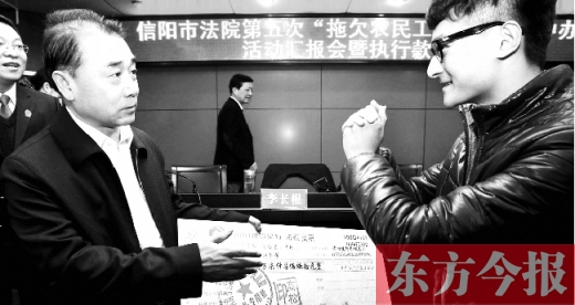 張立勇將依法執(zhí)行回來的農(nóng)民工工資發(fā)放給案件當(dāng)事人游昌華，游昌華施以中國傳統(tǒng)作揖禮答謝
