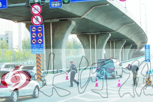 交警在東風(fēng)路從北向南上橋口處擺上反光錐，間歇放行