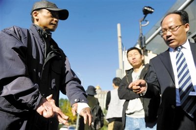 常林鋒在法院外展示雙手，他稱被燙傷的手因刑訊逼供且未得到及時救治