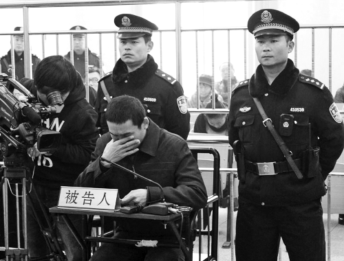 庭審中,29歲的李軍低著頭。