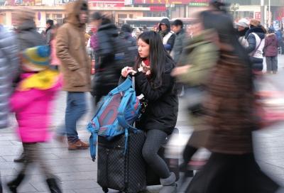 春運(yùn)首日，北京站客流量明顯增多，一名女孩在人流中等待進(jìn)站。