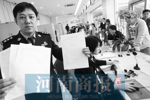 　民警左手拿的是新申請表，右手拿的是三份老申請表 王春勝/攝