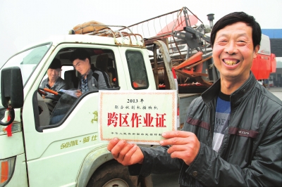 　5月6日，縣嘉應觀鄉(xiāng)東營村農(nóng)機手荊占通在展示他的跨區(qū)作業(yè)證。當日，該縣60多臺履帶式收割機奔赴四川