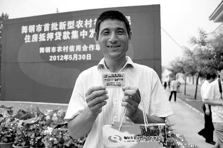 領(lǐng)到貸款，農(nóng)民開心地笑了。