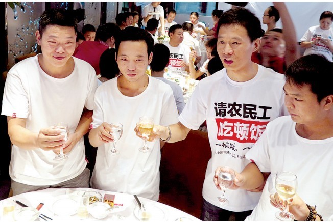 活動發(fā)起人張楠（右二）給農民工敬酒。