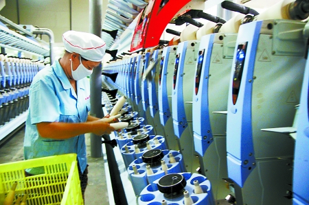 7月3日，在鄧州市永泰棉紡有限公司電腦控制全自動(dòng)紡紗車間，紡織工人正在生產(chǎn)棉紗。