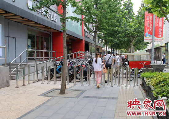 圖中道路左側(cè)的無障礙通道被鋼管隔離,右側(cè)的盲道也被侵占。