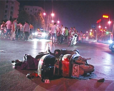 一輛白色無牌奧迪轎車在通過路口時(shí)，將一名騎電動(dòng)車的女子撞飛十多米
