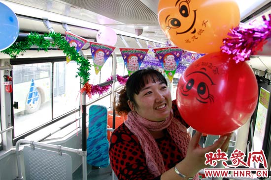 鄭州快速公交B3區(qū)間線車長李鵬云在車廂里懸掛氣球，布置圣誕車廂，營造歡樂圣誕氛圍