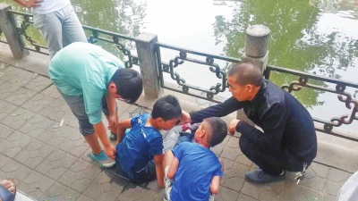 男孩被救出后，圍觀群眾幫他控水換衣服。