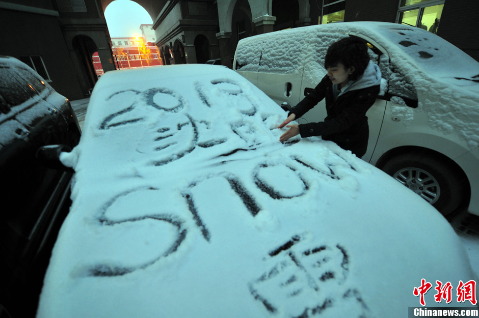 11月18日，行人在車輛的積雪上涂鴉。