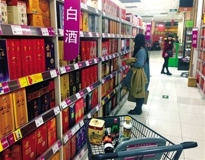 顧客在商場(chǎng)的高檔白酒貨架前駐足挑選。春節(jié)臨近，受“禁令”影響，以高檔白酒為代表的節(jié)日禮品市場(chǎng)面臨考驗(yàn)。記者 王遠(yuǎn)征 攝