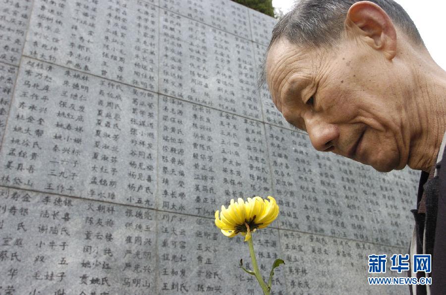 2006年4月5日，74歲的南京大屠殺幸存者佘子清手捧鮮花，祭奠被日軍殺害的母親。