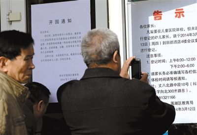 昨日，家長(zhǎng)在西安市楓韻幼兒園查看有關(guān)兒童體檢的告示。