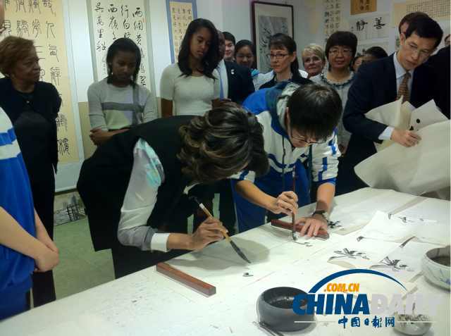 　北京時間3月21日，美國第一夫人米歇爾參觀北師大二附中時，與學生一起練習書法。