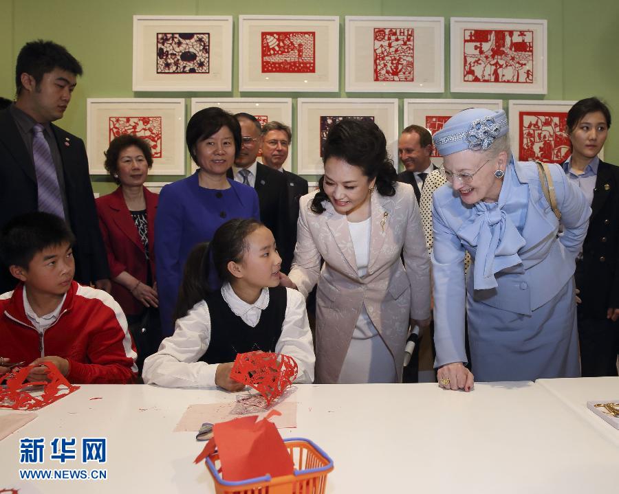這是彭麗媛和瑪格麗特二世與根據(jù)安徒生童話中人物和情節(jié)制作剪紙的孩子交談。