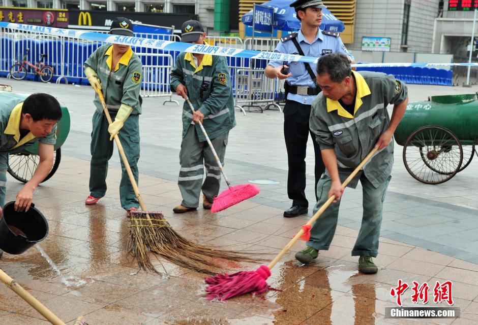 圖為環(huán)衛(wèi)工人在清理案發(fā)地點(diǎn)的血跡。