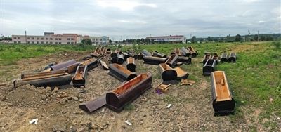40多副棺木被砸壞后，扔在荒地上。