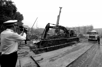 學(xué)院南路一科研樓項目有3臺挖掘機(jī)違規(guī)進(jìn)行土方作業(yè)，被城管隊員當(dāng)場責(zé)令停工。京華時報記者歐陽曉菲攝