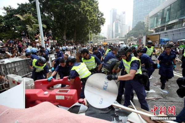 10月14日，警方清除金鐘道障礙物。大批警員在金鐘道現(xiàn)場(chǎng)清拆障礙物。部分警員戴上頭盔將障礙物移走。