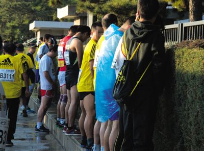2013年10月20日，北京馬拉松比賽，由于廁位有限，一些選手在綠化帶“就地解決”。圖/IC
