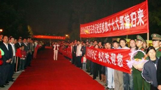 “夾道歡迎”中不少人打出橫幅，路上被鋪上了紅毯。