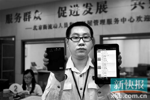 　越秀區(qū)北京街出租屋外來暫住人員管理服務(wù)中心的工作人員展示到出租屋登記來穗人員信息的儀器。