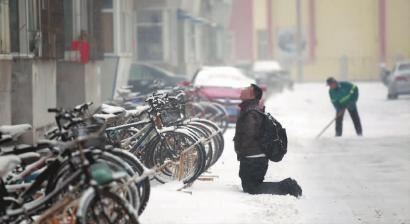 小伙子跪在樓前，一直抬頭看著樓上。 孫立國(guó)/攝